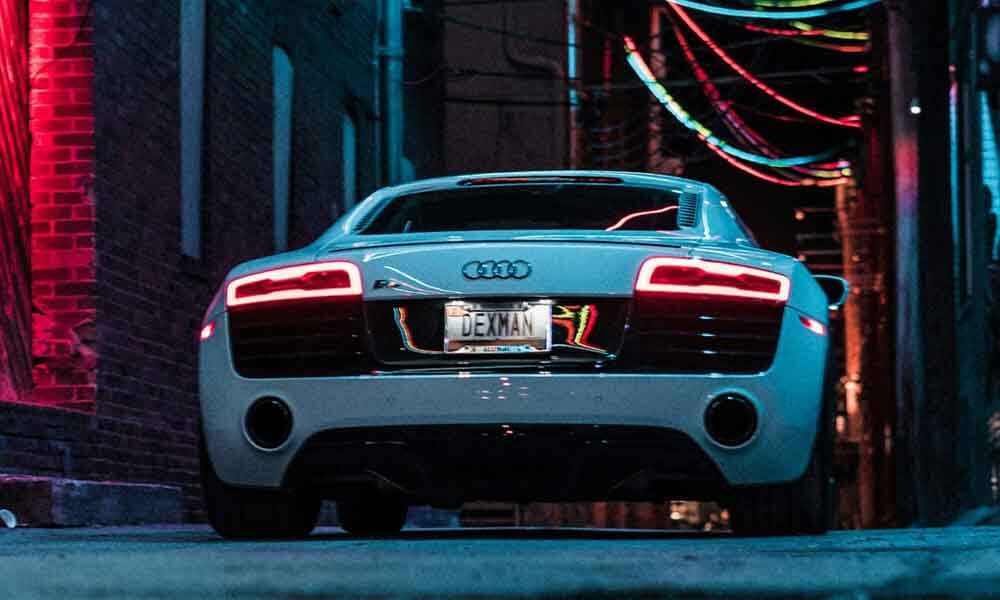 Audi supercar reflecting neon lights of the city