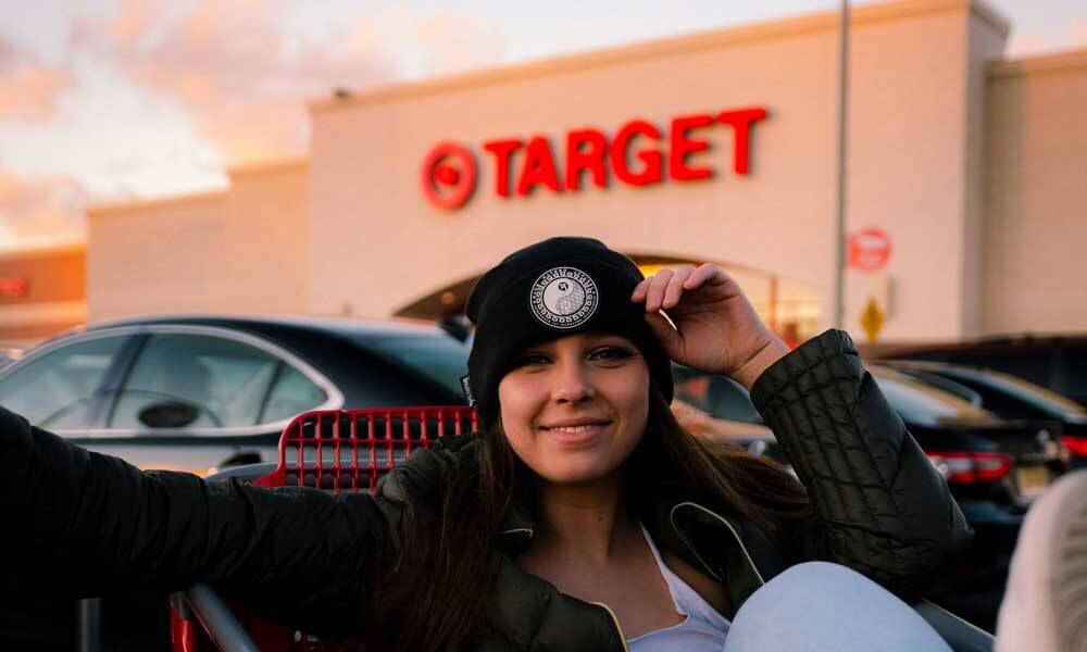 Girl casually sitting in a shopping cart in front of Target store