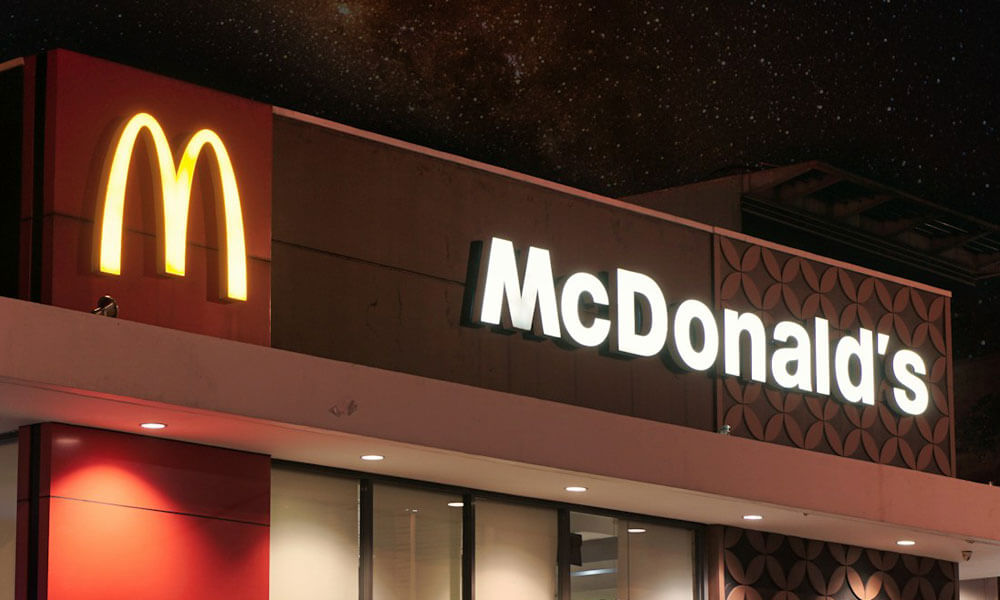 McDonald's sign at front of outlet lit up at night