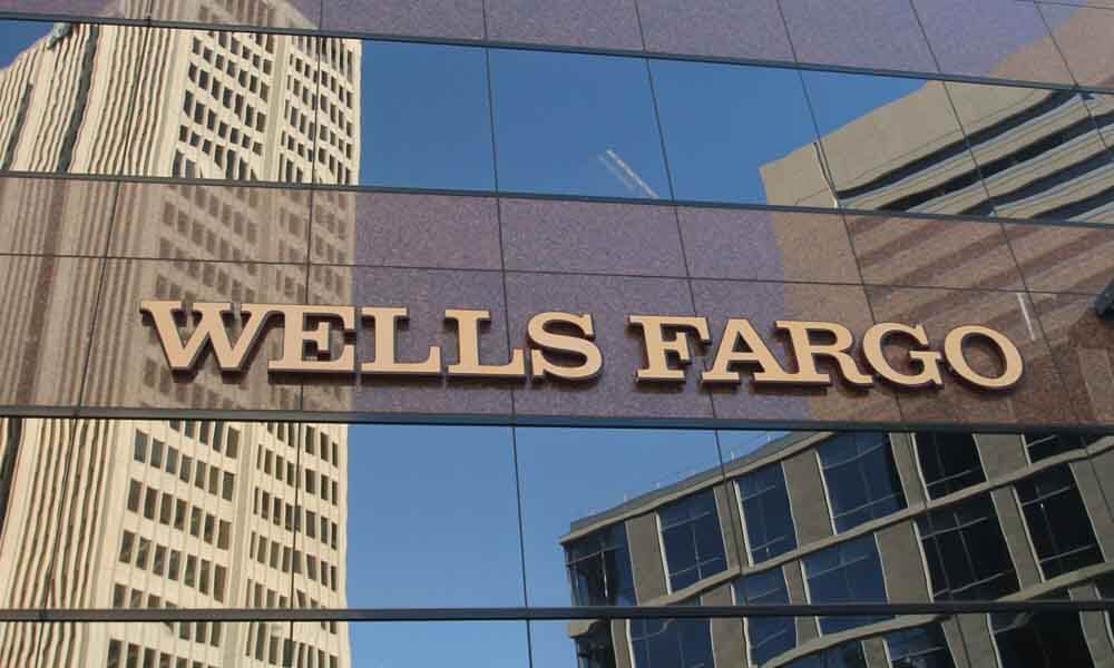 Wells Fargo logo sign in front of glass building